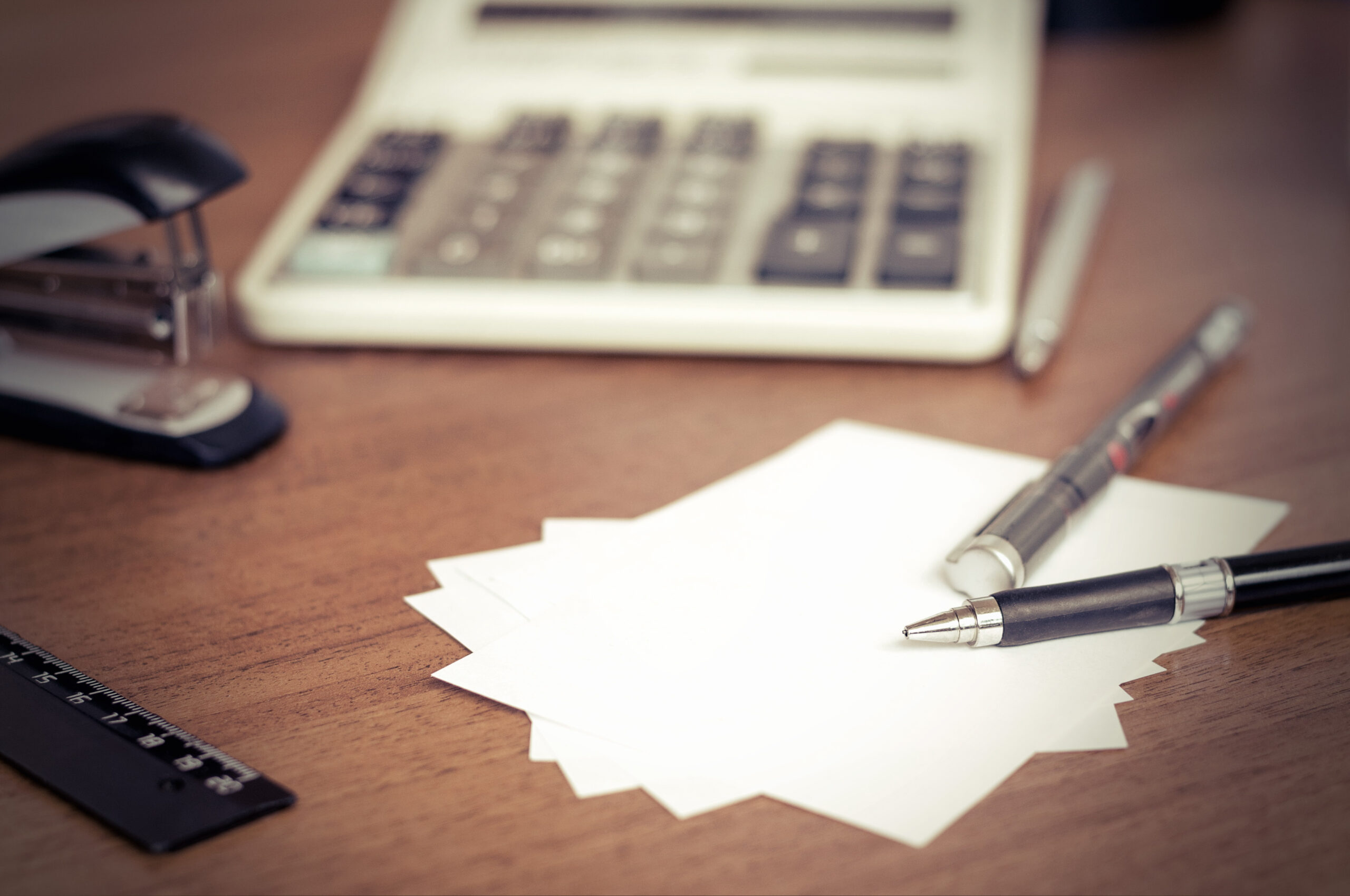 Irodai környezetben papírok és számológép az asztalon – adóregisztrációs eljárás, NAV-ellenőrzés illusztráció.